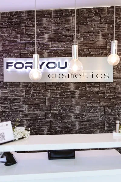 Empfang mit dem Schriftzug FOR YOU cosmetics an der Steinwand